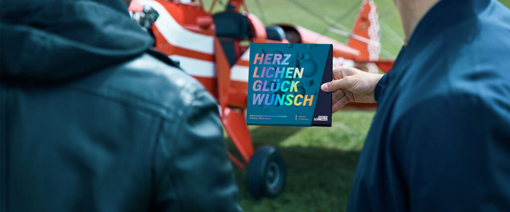 Personen betrachten Geschenkverpackung Herzlichen Glückwunsch von Jochen Schweizer