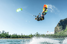 Person die einen Salto mit einem Kite auf dem Wasser macht.