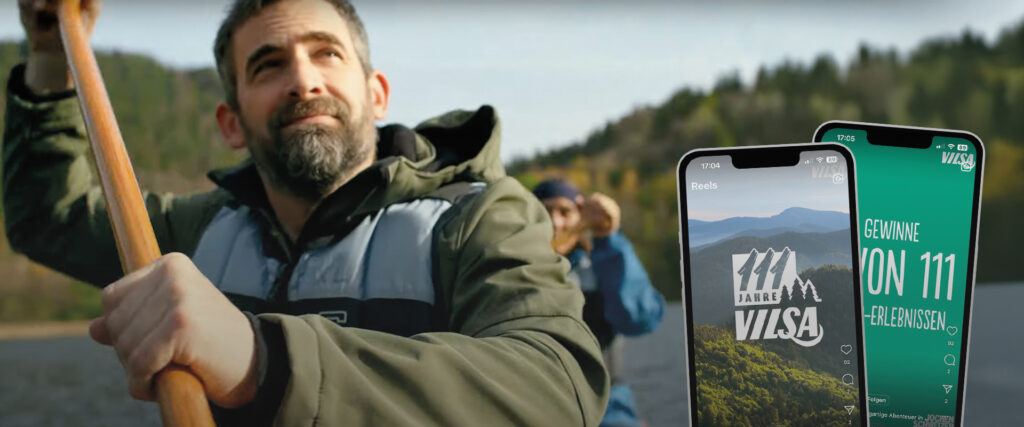 Personen in Ruderboot auf dem Wasser und Vilsa Gewinnspiel im Vordergrund auf Handyscreens