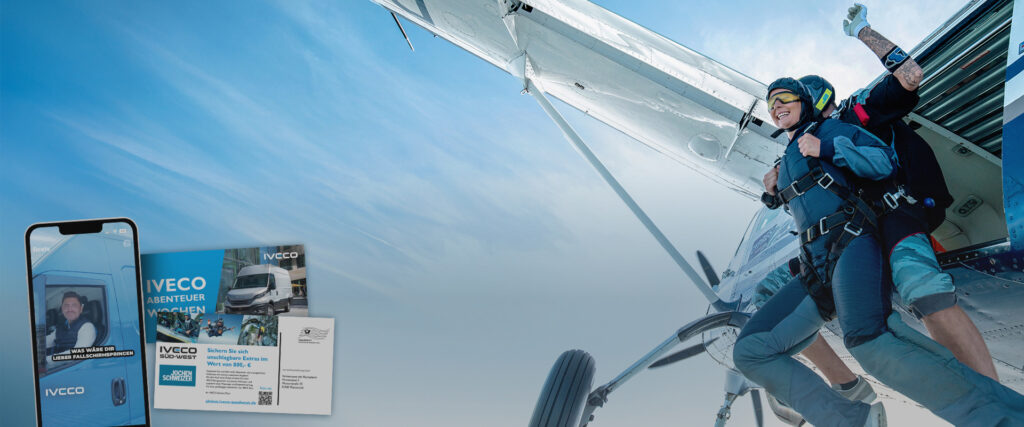 Zwei Personen springen im Tandemsprung aus dem Flugzeug.