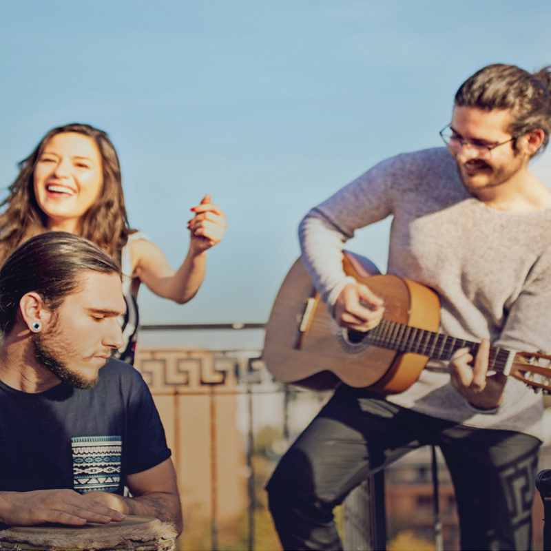 Personen auf Dachterrasse tanzen zu Live-Musik