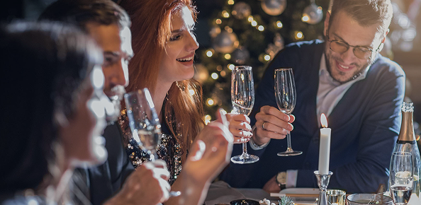 Eine Gruppe, die bei weihnachtlicher Stimmung an einem Tisch zusammen sitzt