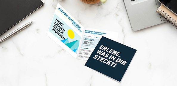 Wertgutschein von Jochen Schweizer auf einem Tisch mit Schriftzug "Herzlichen Glückwunsch"